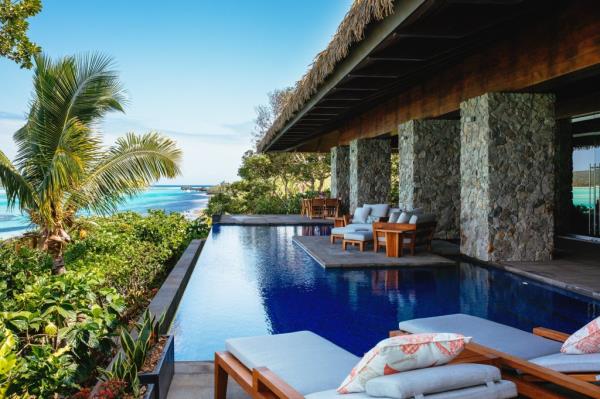 A villa features serene outdoor seating and a pool.