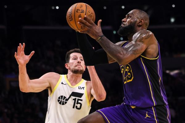 Los Angeles Lakers forward LeBron James, right, scores against Utah Jazz forward-center Drew Eubanks during the second half of an Emirates NBA Cup basketball game, Tuesday, Nov. 19, 2024, in Los Angeles.
