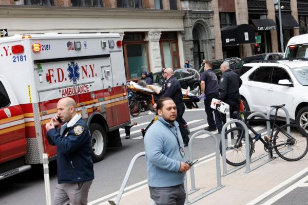 Image depicts graphic content)  Paramedics attend to a person who lit themselves on fire near Manhattan Criminal Court on April 19, 2024 in New York City.