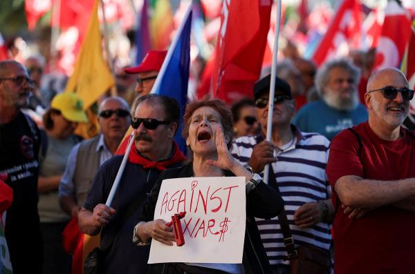 A woman shouts as she holds a sign that reads 