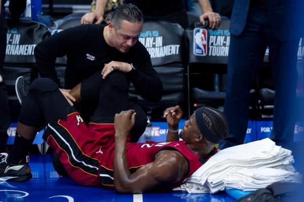 Miami Heat's Jimmy Butler receiving treatment on his right knee from the training staff during an NBA basketball game against the Philadelphia 76ers