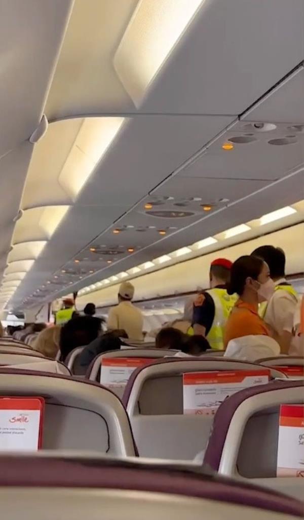 Security is seen escorting the man and his friends off the plane.