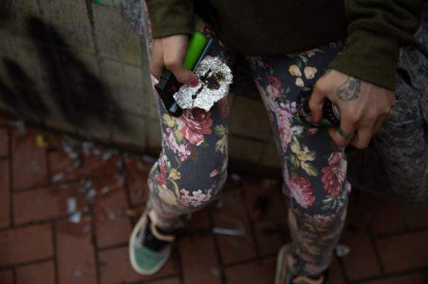 A person holds drug paraphernalia near the Washington Center building on SW Washington St. in downtown Portland, Ore.