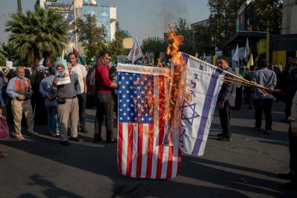 Iranian demo<em></em>nstrators set fire to Israeli and American flags during an anti-Israeli-American demo<em></em>nstration in Palestine Square on October 8,