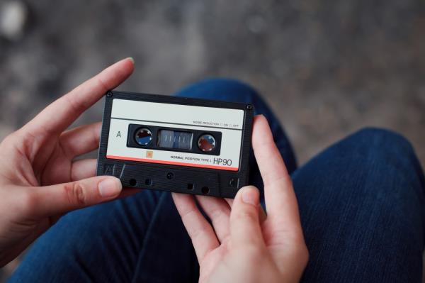 Girl holding a Walkman and cassette tape