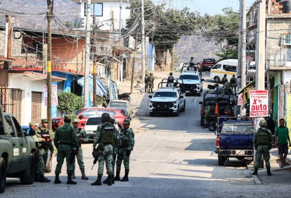 Natio<em></em>nal Guard and army perso<em></em>nnel guard an area wher<em></em>e four bodies were found in Acapulco.