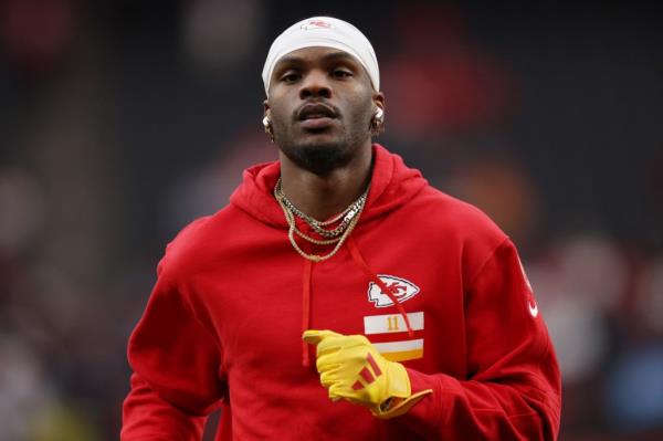 Marquez Valdes-Scantling #11 of the Kansas City Chiefs wearing red sweatshirt and yellow gloves, warming up for Super Bowl LVIII in Las Vegas.
