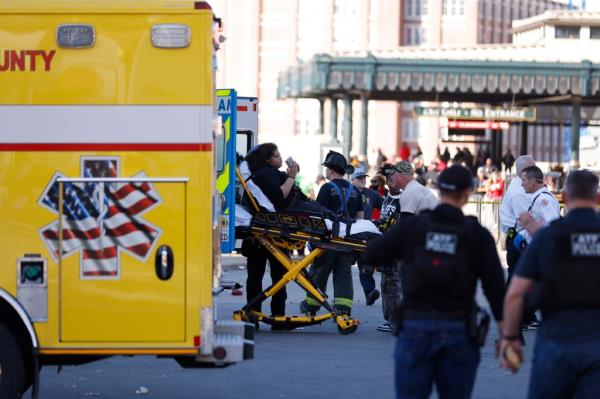 A person on a stretcher being loaded into an ambulance during Kansas City Chiefs Super Bowl victory parade.