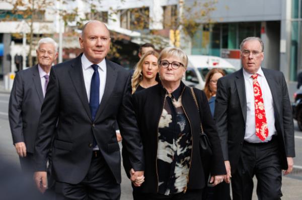 Reynolds arrives with husband Robert Reid (left) and lawyer Martin Bennett (right) at the WA Supreme Court.