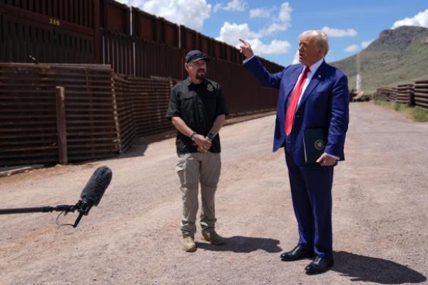 Do<em></em>nald Trump listens to Paul Perez, president of the Natio<em></em>nal Border Patrol Council, as he tours the southern border in Arizona. 