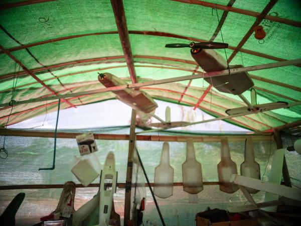 Drone parts in hanging up in a green tent