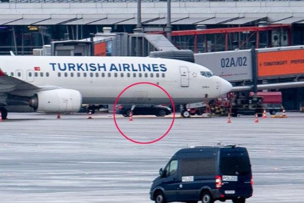 A police van observe the car of a hostage taker seen parked under a Turkish airline plane on the tarmac at the airport in Hamburg, northern Germany on November 5, 2023. Air traffic at Hamburg airport remained suspended Sunday over a suspected hostage situation on the tarmac involving a child, local authorities said. A gunman rammed his car through the security area o<em></em>nto the apron wher<em></em>e planes are parked on Saturday evening, firing two shots in the air and flinging two burning bottles out of the vehicle, police said. (Photo by NEWS5 / Schrder / NEWS5 / AFP) (Photo by NEWS5 / SCHRODER/NEWS5/AFP via Getty Images)