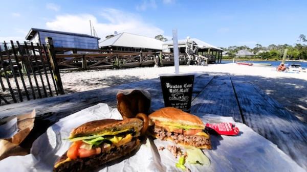 There's nothing pretentious a<em></em>bout it: A burger and a bushwacker at Pirates Cove, a venue wher<em></em>e patrons are as likely to arrive by boat as by car.
