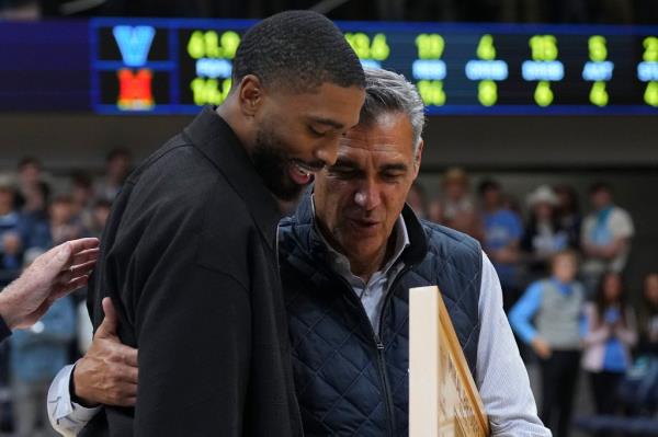 Nets star Mikal Bridges hugs former Villanova coach Jay Wright after havin<em></em>g his number retired by the school during a halftime ceremony.