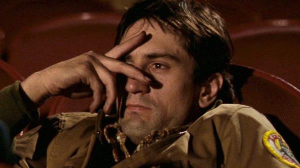travis bickle sits in a movie theater in the film taxi driver