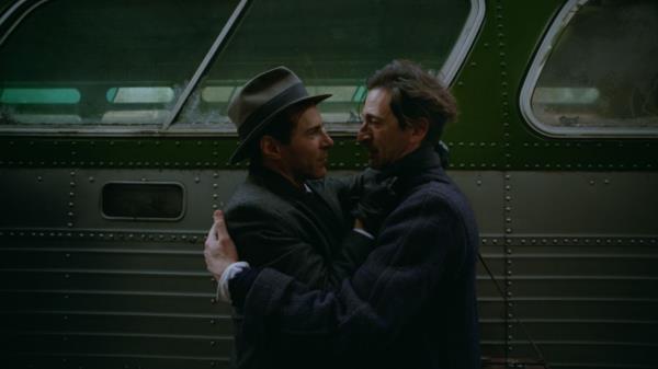 two men hold each other in the film the brutalist